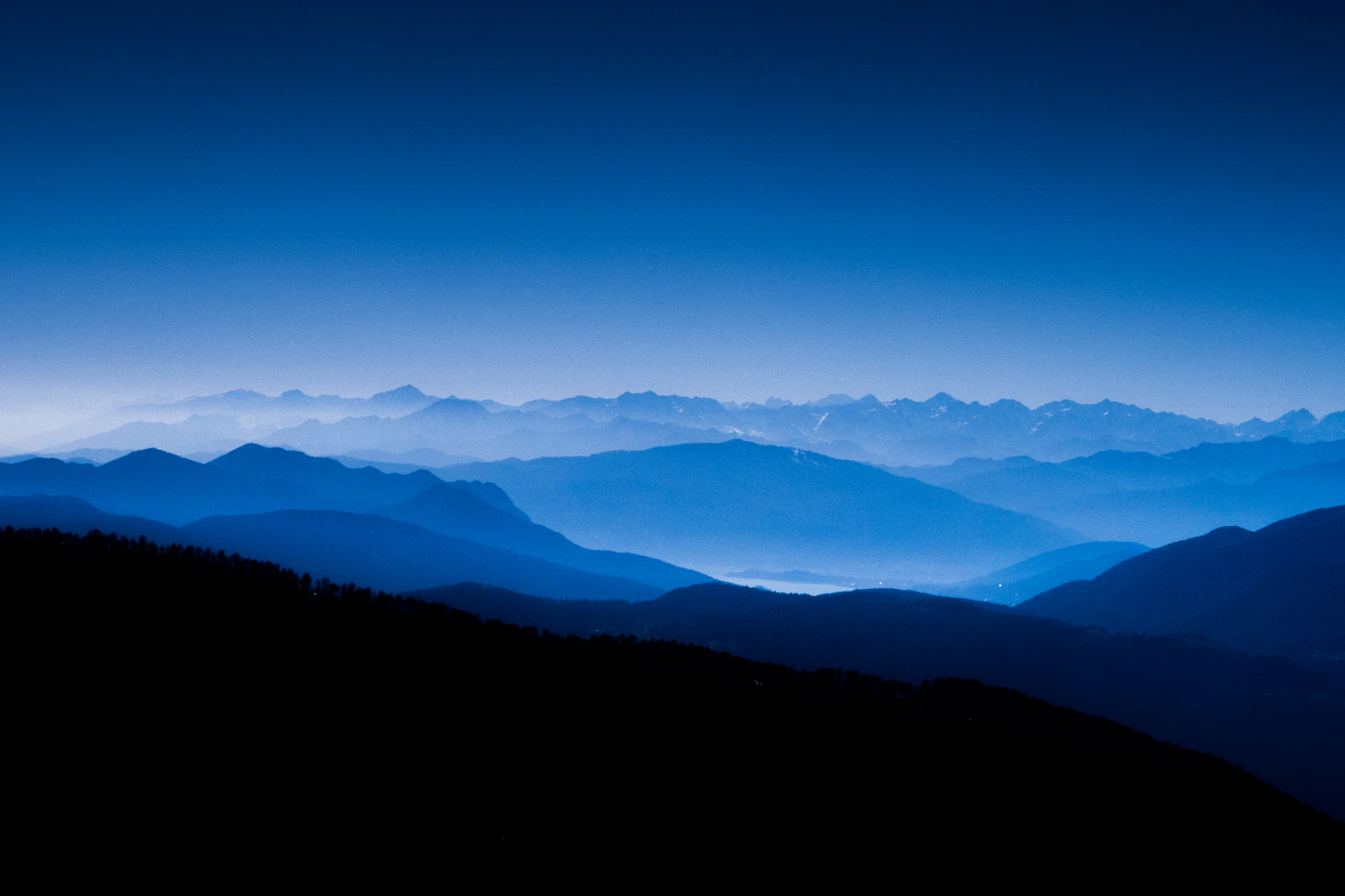Layered blue mountain ridges fading into a misty horizon